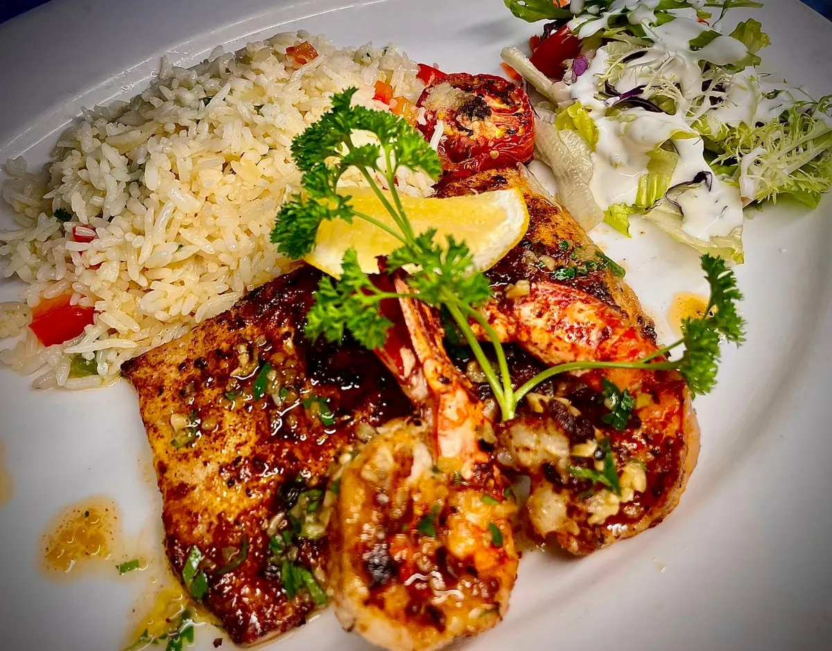 Grilled prawns and fish with rice and salad, plated at Bamboo